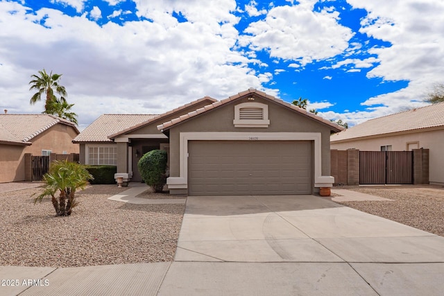 view of front of house with driveway, an attached garage, fence, and stucco siding