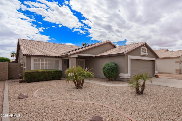 ranch-style home with a garage, concrete driveway, a tiled roof, and stucco siding