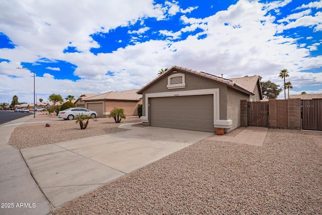 ranch-style home with stucco siding, a gate, a garage, driveway, and a tiled roof