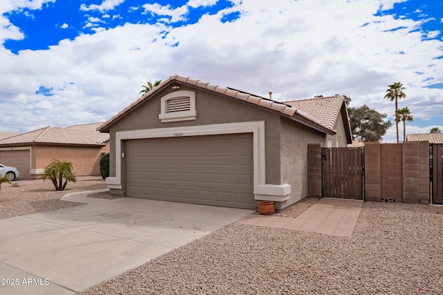 view of front of house featuring a garage, a tiled roof, driveway, a gate, and stucco siding