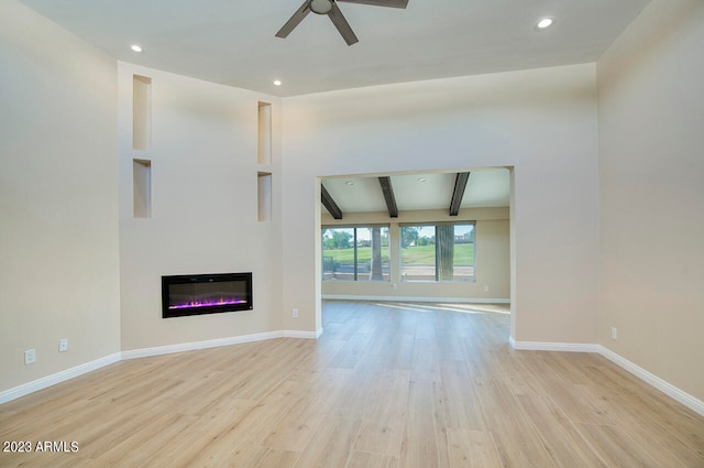 unfurnished living room with light hardwood / wood-style floors, beamed ceiling, and ceiling fan