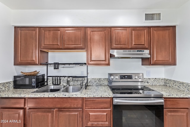 kitchen featuring light stone countertops, electric stove, and sink