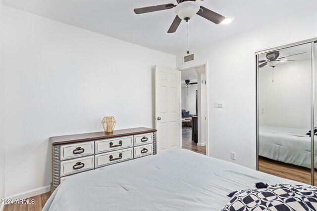 bedroom featuring wood-type flooring, a closet, and ceiling fan