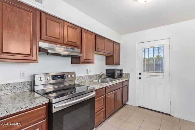 kitchen featuring light stone counters, electric range, light tile patterned flooring, and sink