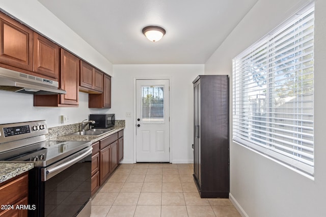 kitchen featuring electric stove, light tile patterned floors, light stone counters, and sink