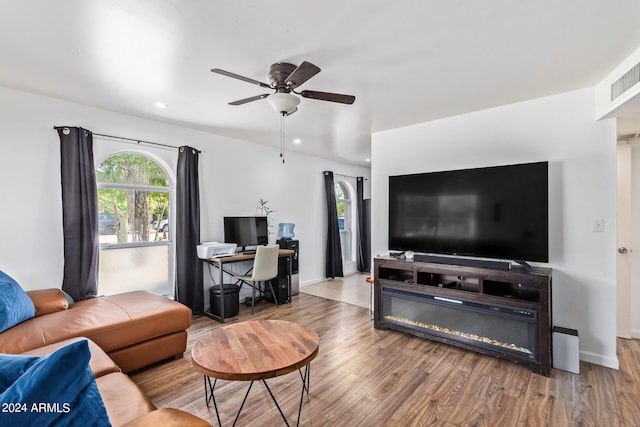 living room featuring ceiling fan and hardwood / wood-style flooring