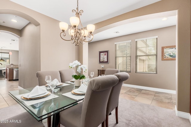 dining area featuring baseboards, arched walkways, visible vents, and light tile patterned flooring