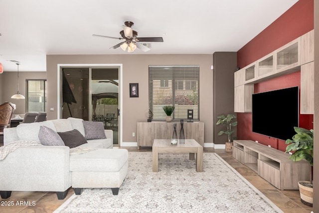 living room featuring baseboards and ceiling fan