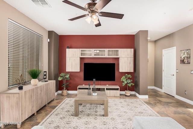 living room with visible vents, baseboards, and ceiling fan