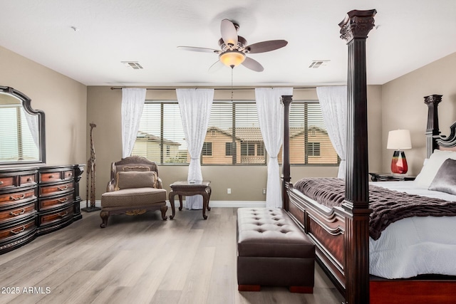 bedroom featuring visible vents, multiple windows, and light wood-style floors