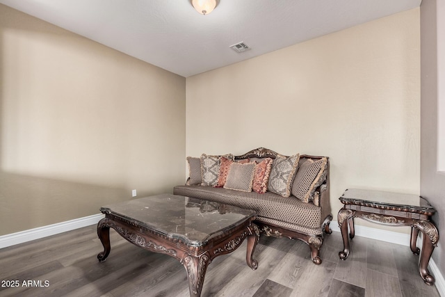 living area with visible vents, baseboards, and wood finished floors