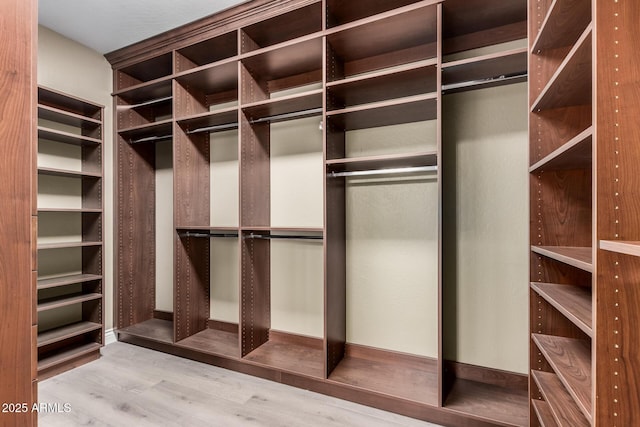 walk in closet with wood finished floors