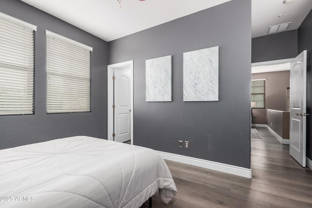 bedroom with wood finished floors and baseboards