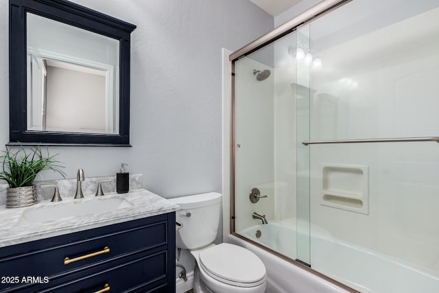 full bathroom with bath / shower combo with glass door, toilet, and vanity