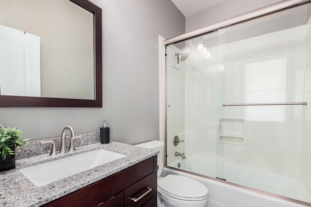 bathroom featuring combined bath / shower with glass door, toilet, and vanity