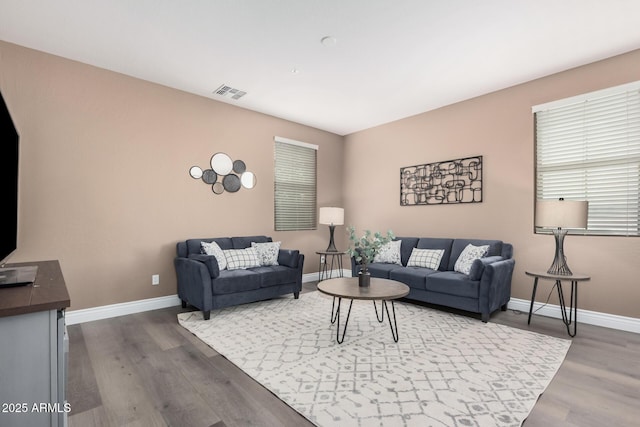 living area featuring dark wood finished floors, baseboards, and visible vents