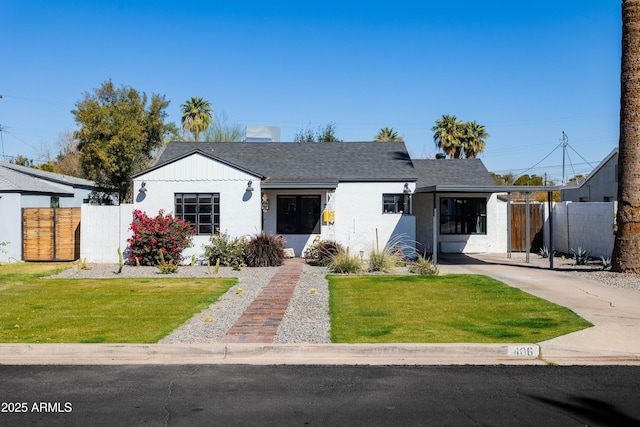 view of front of property featuring fence, driveway, and a front lawn