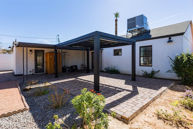 back of property with central air condition unit, a patio area, and brick siding