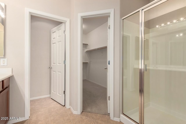 42424 N Gavilan Peak Pkwy Unit 57104, Anthem, AZ 85086 - bathroom with vanity, a shower stall, a spacious closet, and tile patterned floors