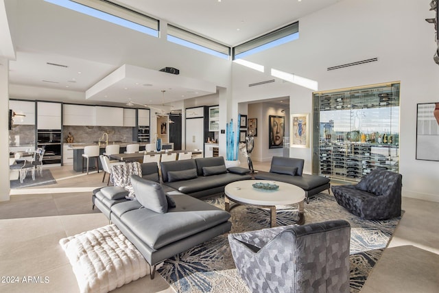 living room featuring a high ceiling and light tile floors