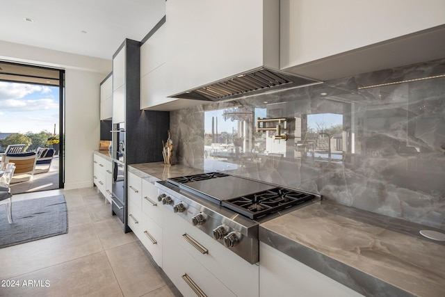 kitchen featuring tasteful backsplash, stainless steel gas cooktop, and white cabinetry