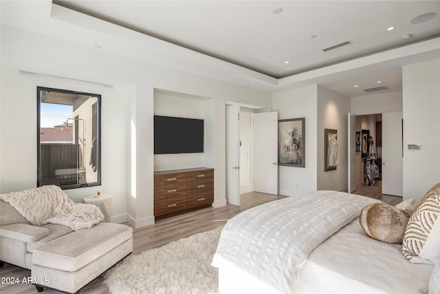 bedroom featuring hardwood / wood-style floors and a tray ceiling