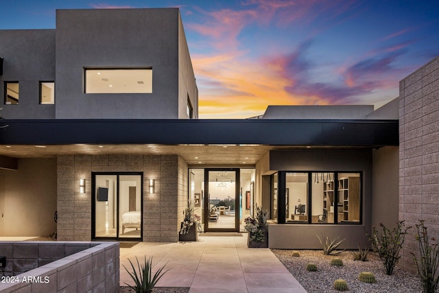 exterior entry at dusk with a patio area