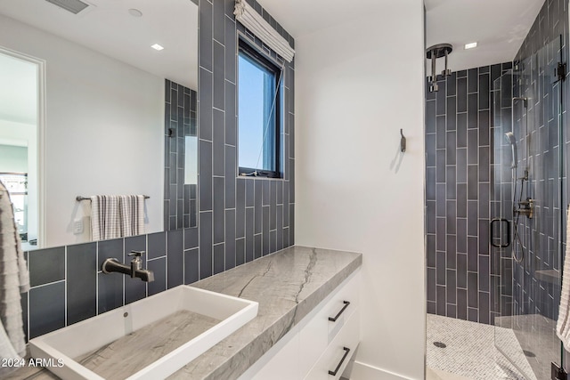 bathroom with tile walls, an enclosed shower, and vanity