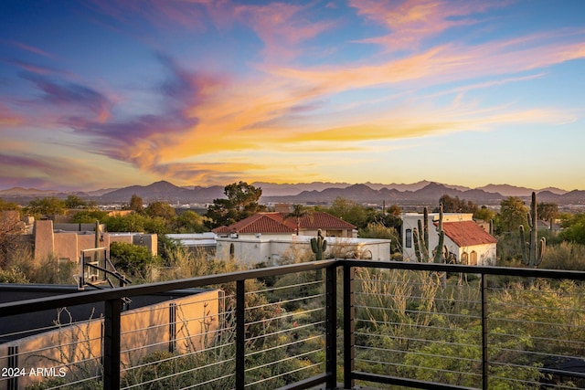 balcony at dusk featuring a mountain view