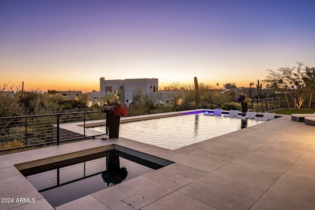 pool at dusk with a patio