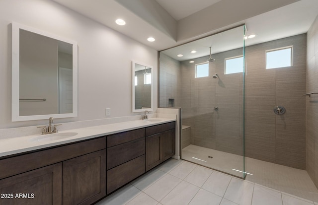 bathroom featuring double vanity, tile patterned flooring, walk in shower, and a sink