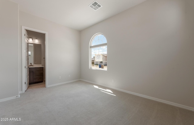 empty room featuring light carpet, visible vents, and baseboards