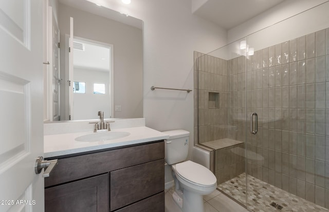 bathroom featuring toilet, a shower stall, and vanity