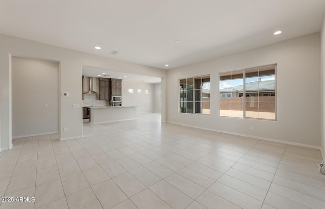 unfurnished living room featuring recessed lighting, a healthy amount of sunlight, and light tile patterned floors