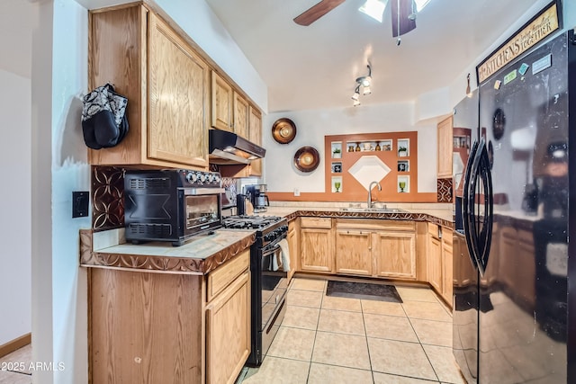 kitchen featuring light brown cabinetry, black appliances, sink, light tile patterned floors, and kitchen peninsula