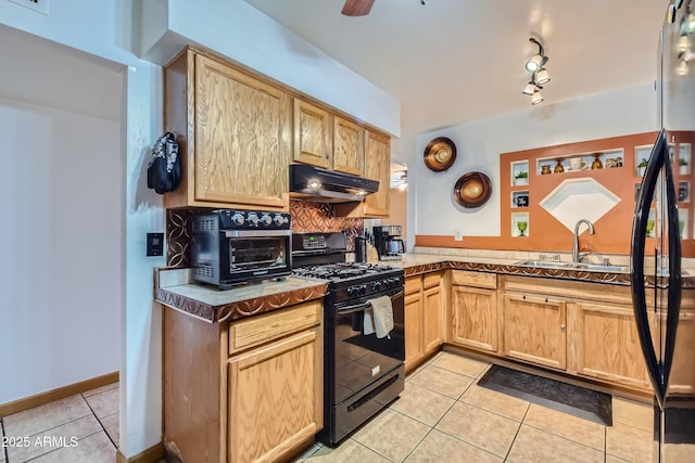 kitchen featuring light tile patterned floors, black range with gas stovetop, and light brown cabinetry