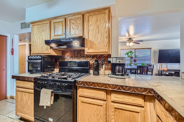 kitchen with black gas range oven, ceiling fan, tasteful backsplash, light tile patterned flooring, and light brown cabinetry