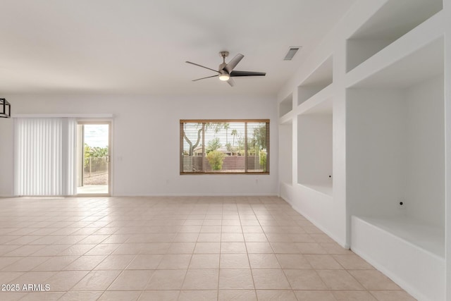 empty room featuring light tile patterned flooring, a ceiling fan, visible vents, and baseboards