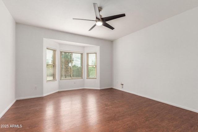 spare room featuring wood finished floors, baseboards, and ceiling fan