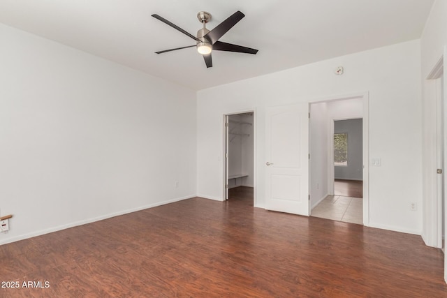 empty room with baseboards, a ceiling fan, and wood finished floors