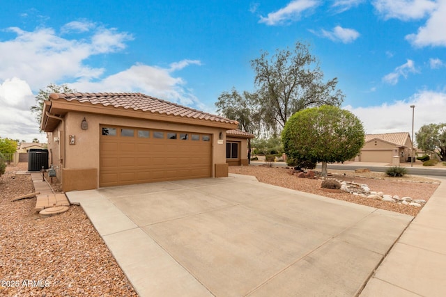 view of front of home with central AC unit, driveway, stucco siding, a garage, and a tile roof