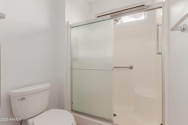 bathroom featuring toilet and a shower stall