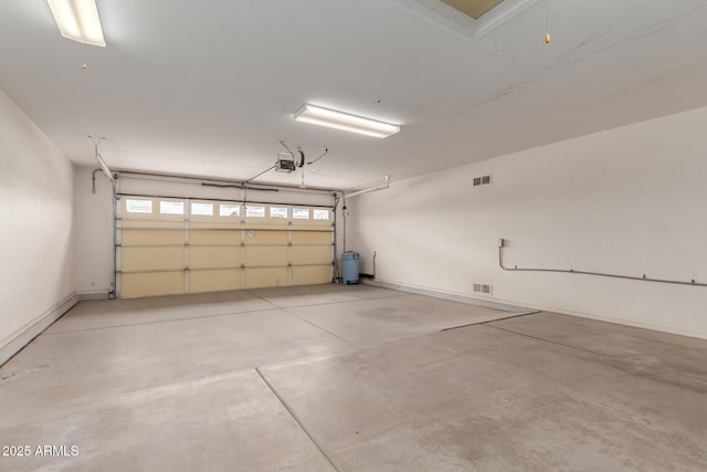 garage featuring a garage door opener and visible vents