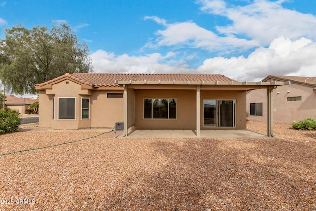 rear view of house featuring stucco siding, a patio, and a tile roof