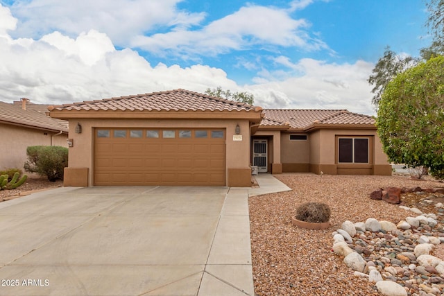 view of front facade with stucco siding, an attached garage, a tile roof, and driveway