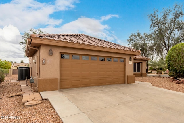 view of front of property featuring stucco siding, cooling unit, concrete driveway, and an attached garage