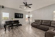 living room featuring ceiling fan and light hardwood / wood-style floors