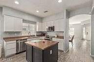 kitchen featuring a kitchen island, stainless steel appliances, and white cabinetry