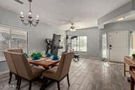 dining space featuring ceiling fan with notable chandelier and hardwood / wood-style floors