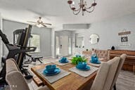 dining space featuring ceiling fan with notable chandelier